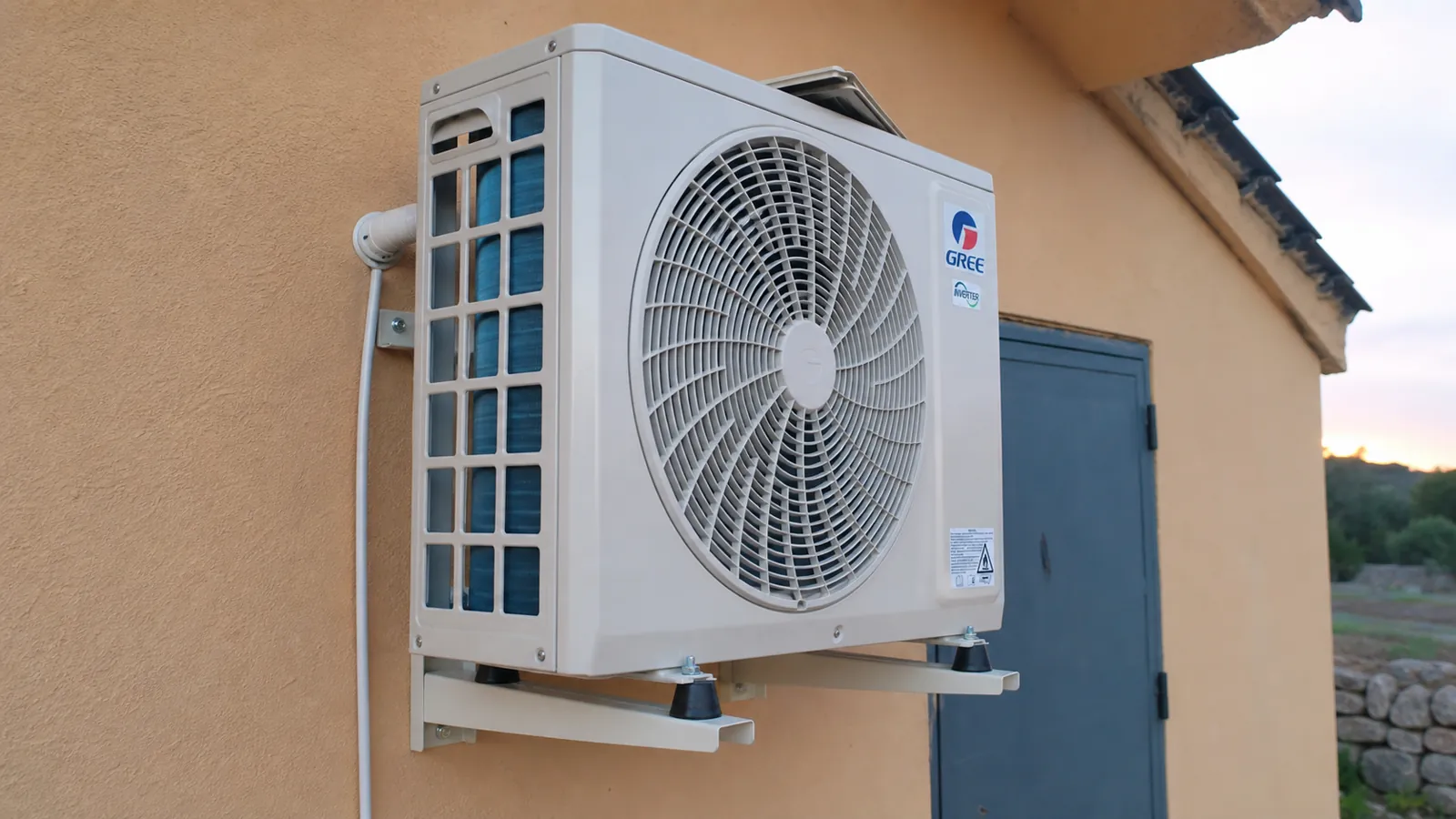 Unidad exterior de aire acondicionado instalada en la fachada de una vivienda